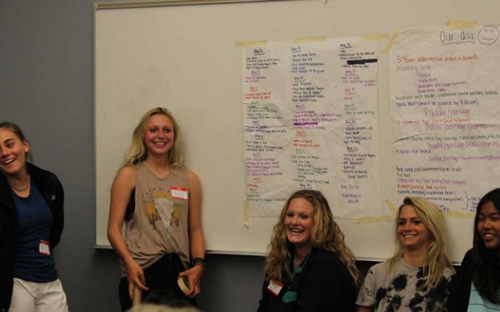 a group of young people stand beside a whiteboard at the family seminar of an outward bound intercept course